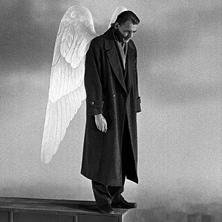 Ein Mann mit Engelsflügeln, der auf einem Hausdach steht.