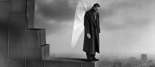 Un hommes avec des ailes qui est sur le toit d'un bâtiment.