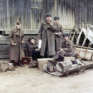 A group of soldiers in outside a barn