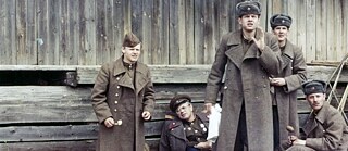 A group of soldiers in outside a barn