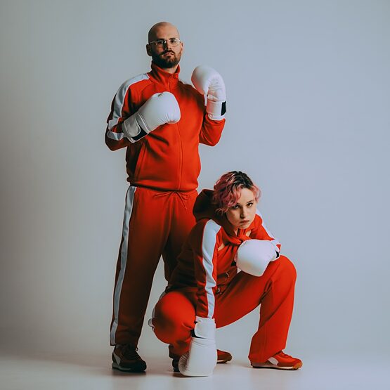 Das Duo vor einer weißen Wand.