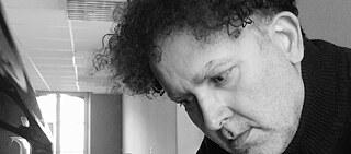 Schwarz-weiß Foto eines Mannes, der Klavier spielt.