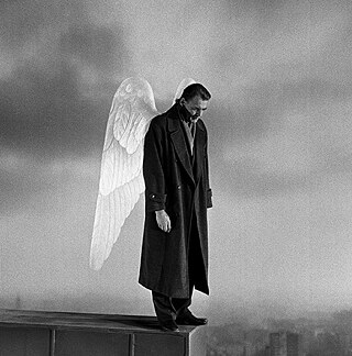 Das schwarz-weiß Bild zeigt eine Person auf einer hohen Mauer stehend im Engelsflügel im Nebel. Im Hintergrund und weitentfernt sieht man die Skyline der Stadt