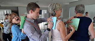 Teachers write on the back of another teacher