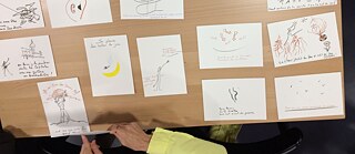 Zeichnungen mit Gedichten auf einem Tisch