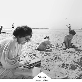 Une photographie en noir et blanc prise sur une plage. Au premier plan, sur la gauche, une personne est assise sur une serviette, légèrement penchée vers l’avant. Elle porte un haut clair à manches longues et tient un livre ouvert dans les mains ; à côté d’elle, posé sur la serviette, se trouve un autre livre fermé. Son regard est dirigé vers le livre. Le sable au premier plan paraît souple et irrégulier, marqué par de petits creux et des traces. Au centre et à droite de l’image, deux enfants jouent dans le sable. L’enfant au centre est accroupi, tournant le dos à l’appareil, et semble creuser ou modeler quelque chose avec ses mains. L’enfant à droite est assis de biais, la tête légèrement inclinée vers le sol, concentré sur son activité dans le sable. Les deux paraissent absorbés par leur jeu. En arrière-plan, on distingue une large étendue de plage qui s’étire jusqu’à une fine ligne d’eau ; la mer semble calme. Tout au fond, des silhouettes floues de baigneurs sont visibles. Le ciel est clair, sans nuages ou avec très peu de nuages, suggérant une journée ensoleillée. En bas de l’image, un élément graphique indique « PAVILLONS » et « Robert Laffont », probablement la mention d’une collection ou d’un éditeur. 