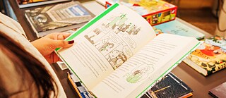 Foto de las manos de una persona sosteniendo un libro abierto