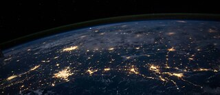 A picture from space. It is night. We see hubs of civilcation connected throught spots of light.