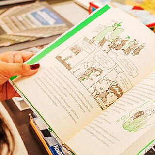 Foto de las manos de una persona sosteniendo un libro abierto