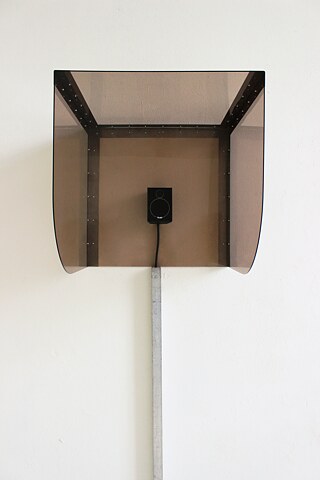 Das Kunstwerk von Johanna Gonschorek besteht aus einer Kombination von Acrylglas und einer Eisenplatte. Es ist Teil einer multimedialen Arbeit, die eine Tonspur integriert.