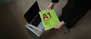 Blick von oben auf eine Deutschlehrerin, die eine Goethe-Prüfung A1 Jugendliche in der Hand hält.