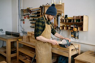 Ein Schreiner arbeitet in einer Schreinerei mit Holz