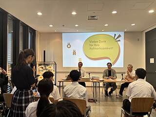 この写真は、在東京ドイツ大使館の職員と会話する生徒たちです。