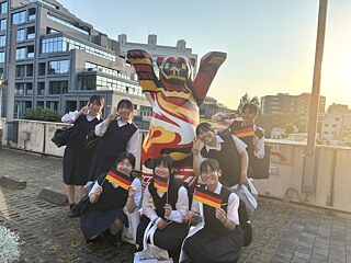 写真は、東京にあるドイツ大使館で、女子学生たちとベルリンの熊の像を撮影したものです。