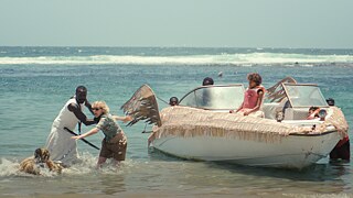 Several people sitting in a boat and two people frantically moving towards the shore.