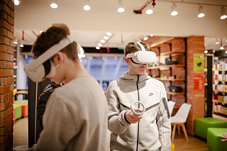 Dois meninos com óculos de RV na cabeça mergulham de forma imersiva em um aplicativo de RV.