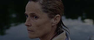 Frau mit Handtuch um den Schultern schaut nachdenklich in die Ferne