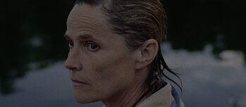 Frau mit Handtuch um den Schultern schaut nachdenklich in die Ferne