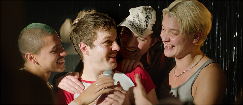 Eine Party: ein junger Mann ist umringt von seinen Freunden