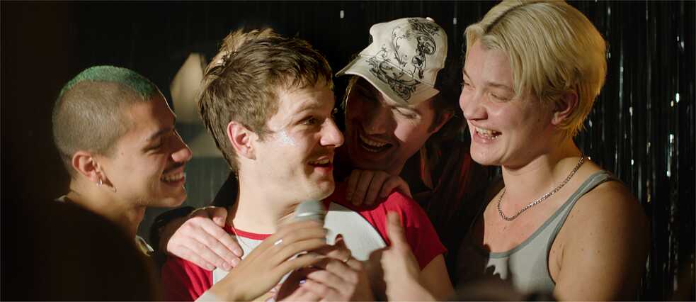 Eine Party: ein junger Mann ist umringt von seinen Freunden