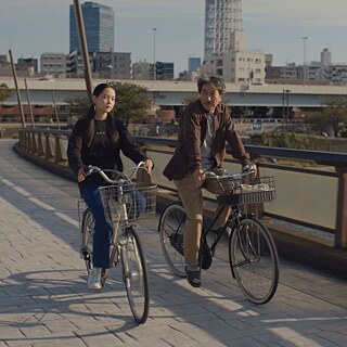 Still from Perfect Days by Wim Wenders - two people on bicycles 