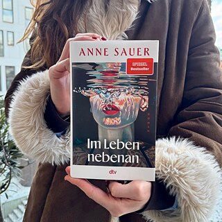 To hænder holder bogen Im Leben neben an af Anne Sauer