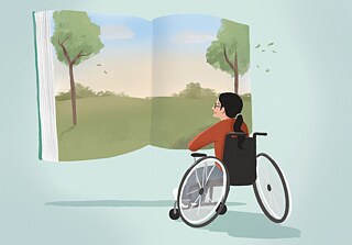 Ein Mädchen im Rollstuhl sitzt vor einem großen geöffneten Buch, das eine grüne Landschaft zeigt. Man sieht sie seitlich von hinten. Sie lächelt.