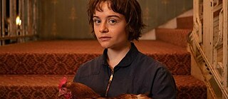 Eine junge Frau mit einem Huhn im Arm