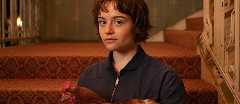 Eine junge Frau mit einem Huhn im Arm