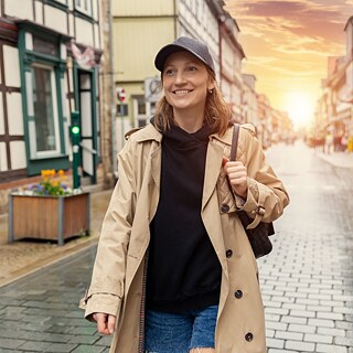 Junge, lächelnde Frau spaziert durch die Stadt