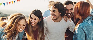 Lachende und tanzende junge Leute bei einer Dach-Party. 