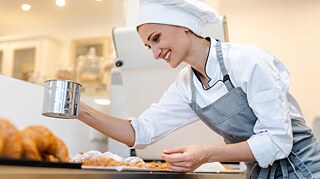 Eine junge Bäckerin bei der Arbeit
