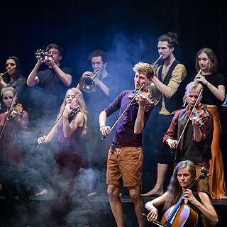 Noored muusikud seisavad laval ja mängivad pilli.