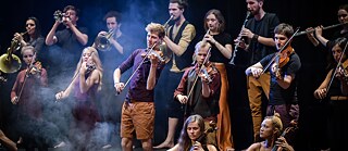 Noored muusikud seisavad laval ja mängivad pilli.