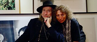 A man and a woman look into the camera