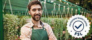 Ein junger Gärtner mit hängenden Blumentöpfen im Hintergrund