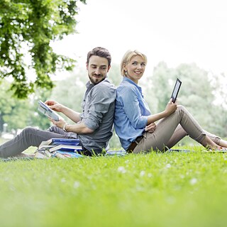 Un giovane e una giovane studiano su un prato
