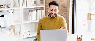 Mann lernt am Laptop mit Kopfhörern