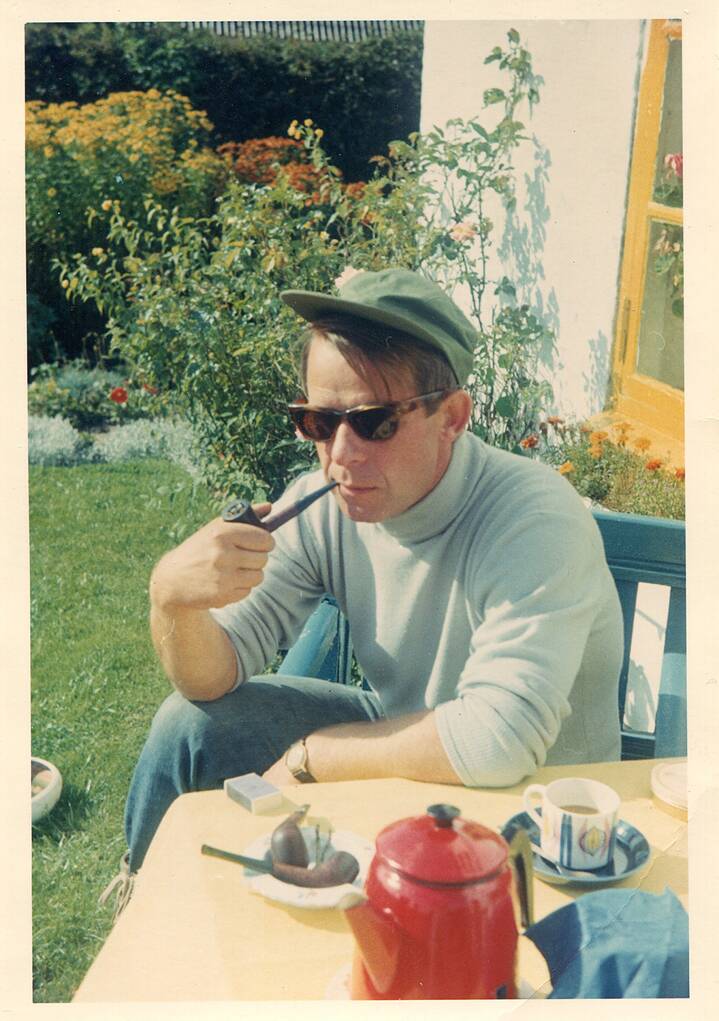 Lenz wearing sunglasses and holding a pipe in his house in Denmark