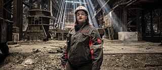 A woman in work-gear looking into the camera