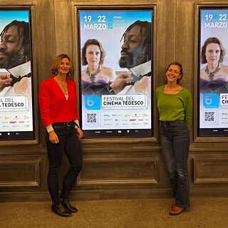 Martina Barone (rechts) und Sarah Wollberg (links) vor den Filmplakaten des 6. Festivals des Deutschen Films in Rom