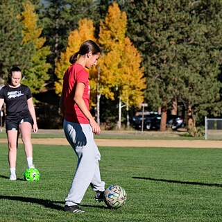 Ein Mädchen, das einen Fußball kickt