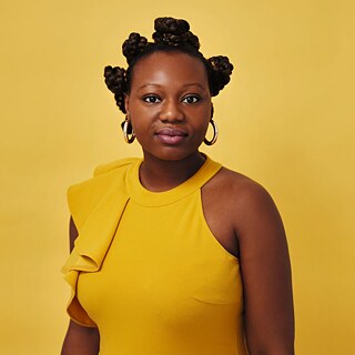 Portrait de Mirrianne Mahn sur fonds jaune. Elle porte une robe jaune et de grands anneaux aux oreilles