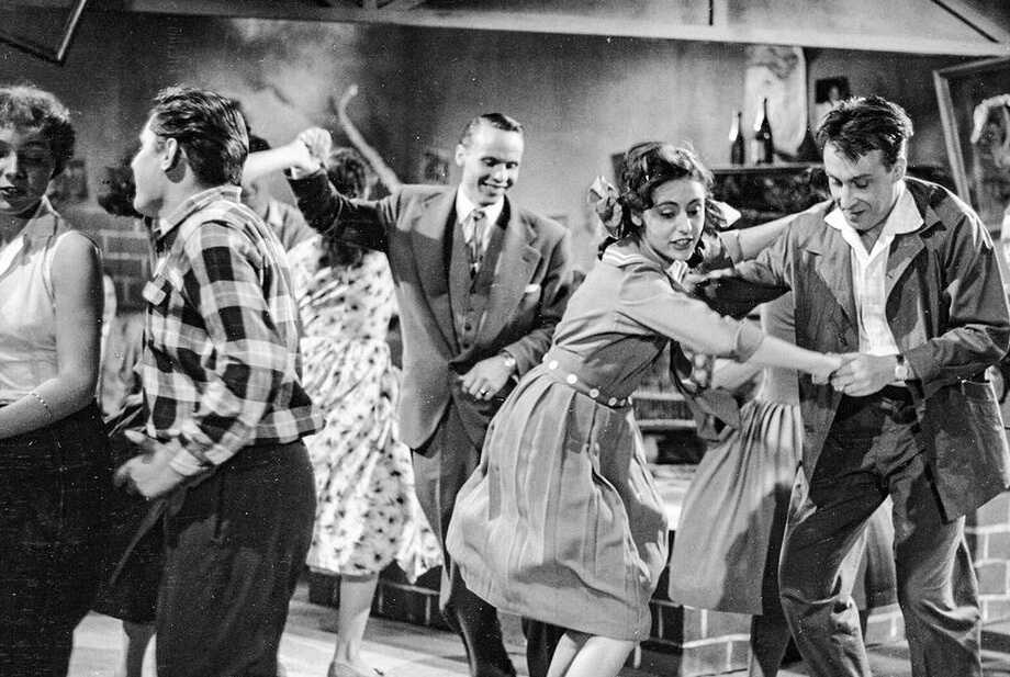 Das Standbild aus „Liebe Tanz und 1000 Schlager“ (1955, Regie: Paul Martin) zeigt eine Gruppe junger Tänzerinnen und Tänzer auf dem Tanzboden. Der Film mit Caterina Valente und Peter Alexander gilt als ein Paradebeispiel des westdeutschen Schlagerfilms der frühen Wirtschaftswunderzeit – eine sorgfältig inszenierte Normalität, in der Gesang, Tanz und Romantik halfen, die jüngste Vergangenheit durch eine gefälligere Gegenwart zu überblenden