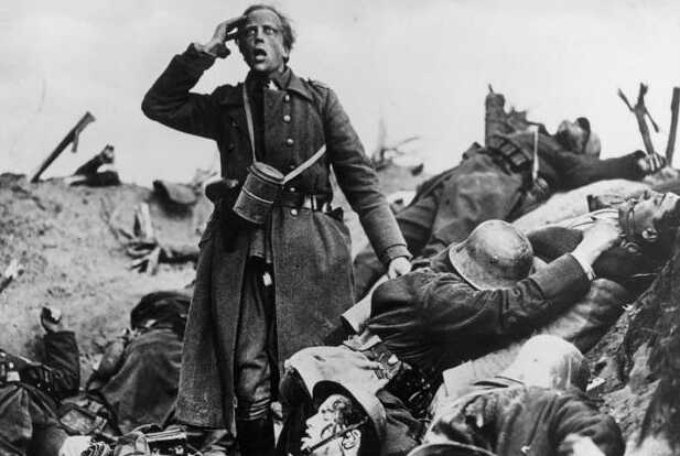 Das Standbild aus „Westfront 1918“ (1930) zeigt einen salutierenden jungen deutschen Soldaten des ersten Weltkriegs in zerrissener Kleidung über einem Schützengraben übersäht mit toten Kameraden und zerstörten Waffen. Mit seinem ersten Tonfilm führte G. W. Pabst den Kriegsfilm in eine neue Ära und schuf ein schonungslos realistisches Porträt des Albtraums, der eine ganze Generation in Deutschland und darüber hinaus geprägt hat. Indem er vier Infanteristen in den Schützengräben Frankreichs während der letzten Monate des Ersten Weltkriegs folgt, zeigt Pabst die brutalen Prüfungen des Kampfes mit bislang unerreichter Natürlichkeit, während die Männer durch Feuergefechte, Bombardements und die Ernüchterung, die sie an der Heimatfront erwartet, nach und nach an Körper und Geist zerbrechen.