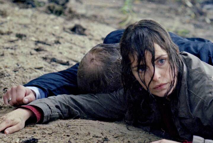 Standbild aus „Yella“ (Christian Petzold, 2007) – Yella geht fort. Sie sehnt sich nach der Zukunft. Sie möchte das Leben, das sie bisher geführt hat, hinter sich lassen, doch immer wieder drängen sich Bruchstücke ihrer Vergangenheit in ihr neues Leben. In diesem Bild liegt Yella in nasser Kleidung neben einem nicht identifizierbaren Mann an einem Flussufer.