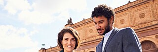  Zwei Teilnehmende beim gemeinsamen Kulturprogramm. Sie stehen vor der Kunsthalle und sehen sich gemeinsam ein Buch an.