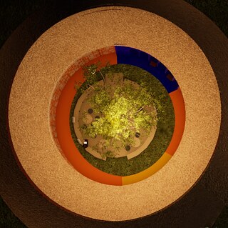 Top-down view of a circular interior space: A brightly lit tree stands at the center, surrounded by seating areas and small tables. Several colored rings— including orange, yellow, and blue—encircle the central area, forming a layered, concentric architectural design.