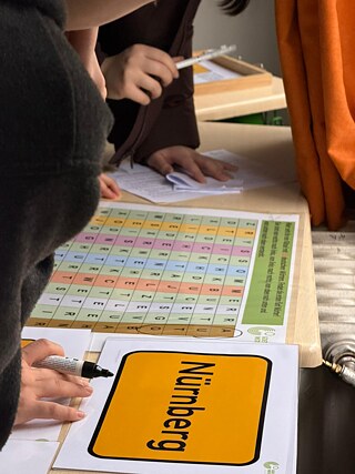 Hände von Schüler*innen über Karten auf denen Vokabeln stehen