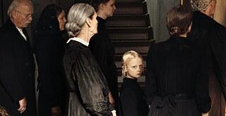 Eine Gruppe von Menschen in altmodischer Kleidung ist von der Seite zu sehen, wie sie nach rechts blicken. In der Mitte schaut ein kleines Mädchen, auf das das Licht fällt, den Betrachter an.